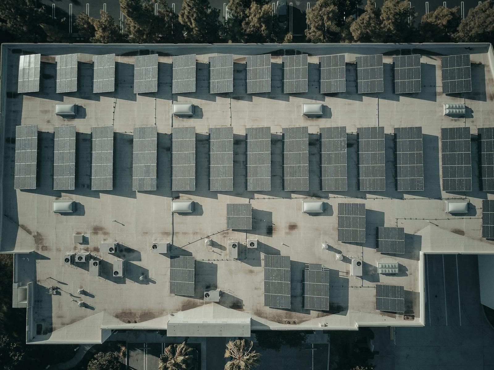 Top-down view of solar panel rows on a large commercial rooftop