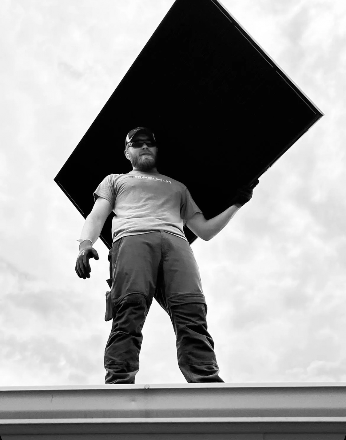 Braven Solar team member carrying a solar panel during a local installation