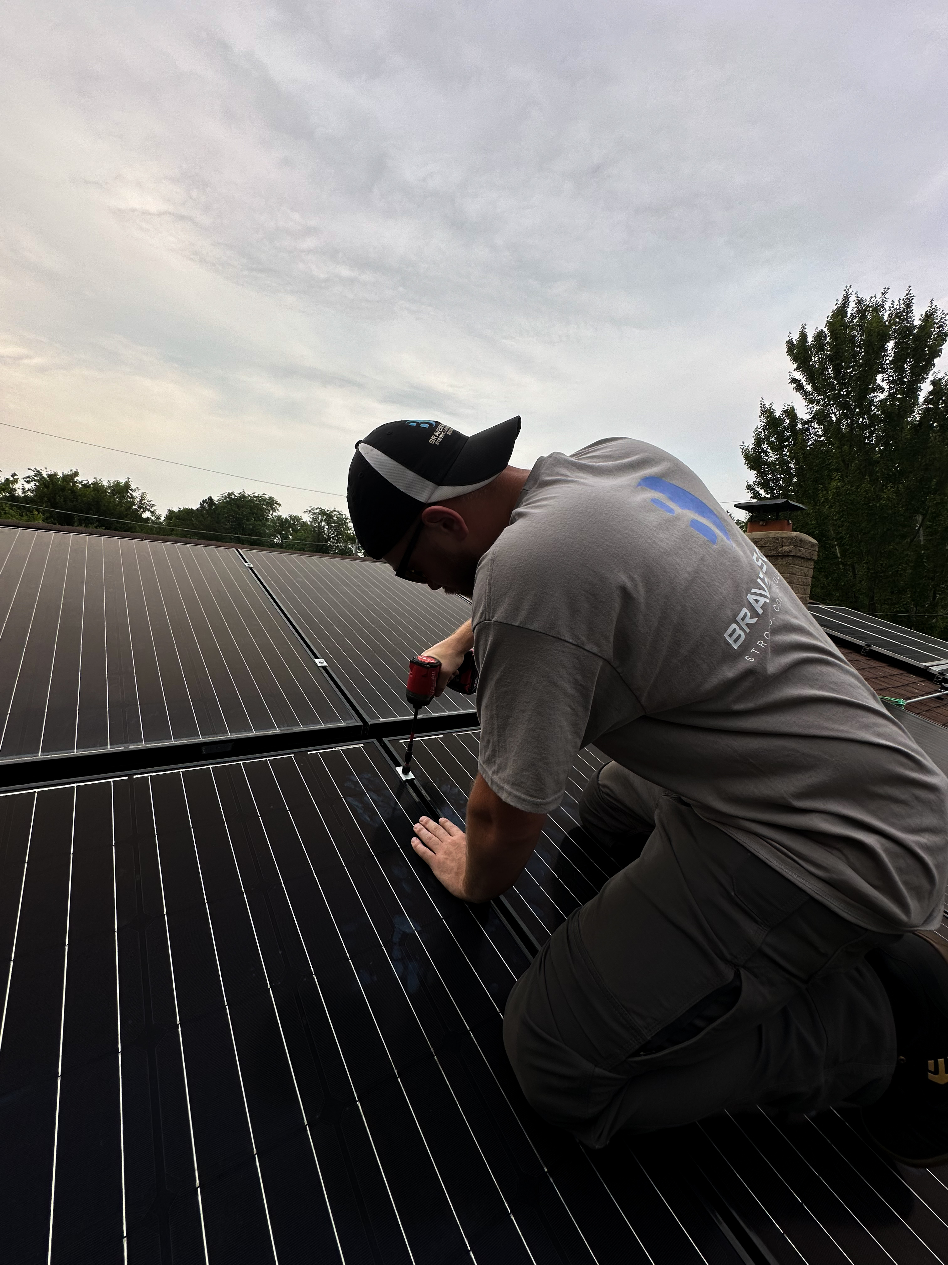 Braven Solar technician fastening rooftop solar panel hardware for detach and reinstall work